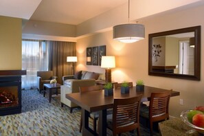 Une chambre d’hôtel avec un coin repas, une cheminée et un grand miroir.