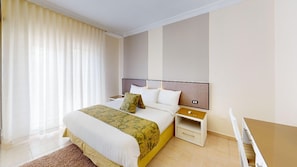 A hotel room with a bed, bedside tables, a desk, and a chair. - Serene 2-bedroom apartment with AC in vibrant Amman (Amman)