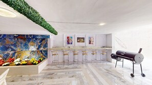 A modern interior with a bar area, a grill station, and a colorful abstract painting. - Serene 2-bedroom apartment with AC in vibrant Amman (Amman)