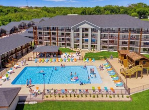 A hotel with a swimming pool, outdoor seating, and a playground. - Creekside walk to downtown, landing, king bed (Branson)
