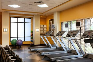 Una palestra con tapis roulant, manubri e palle da ginnastica.