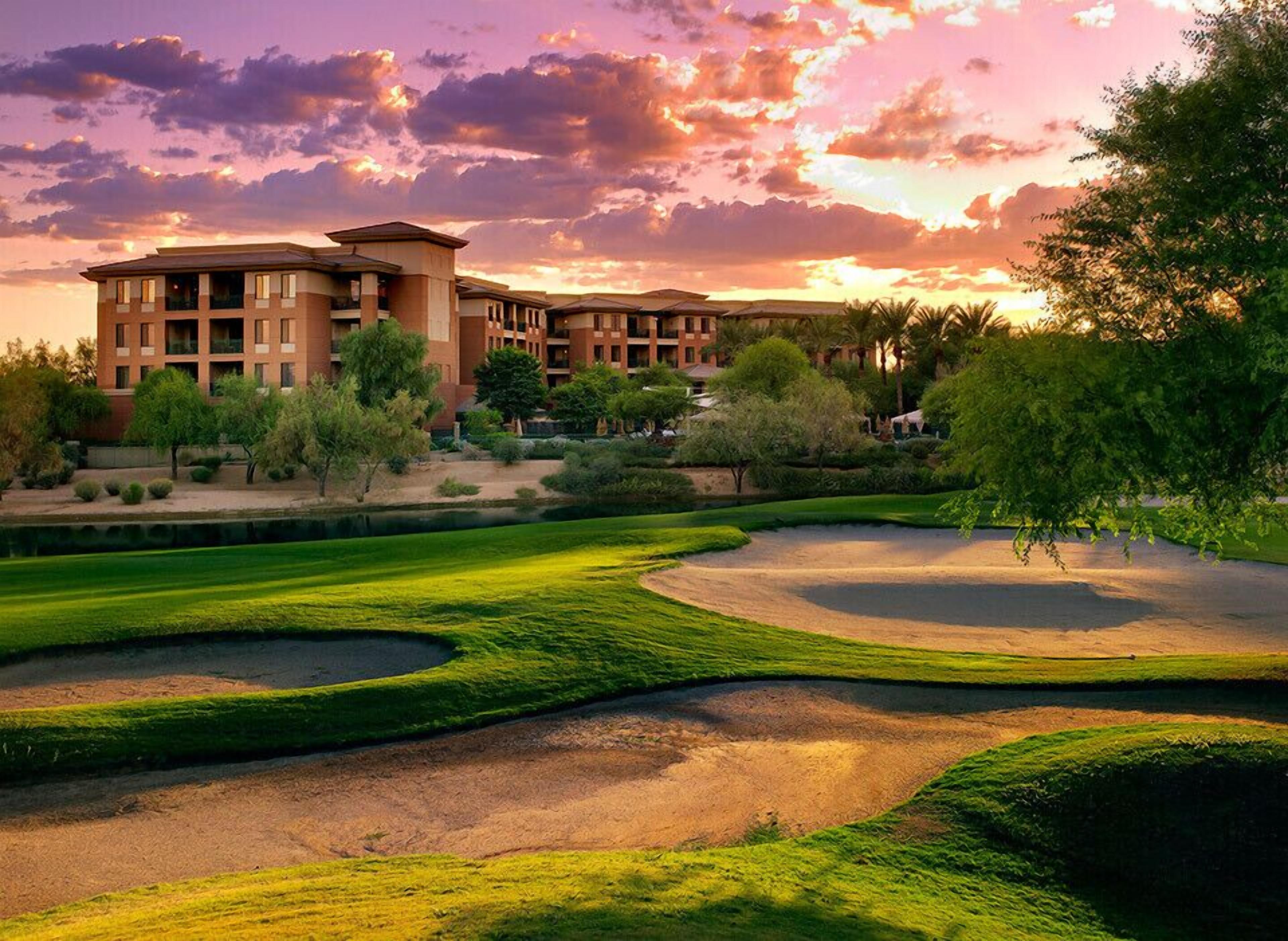 Un campo de golf con búnkeres y un edificio grande al fondo.
