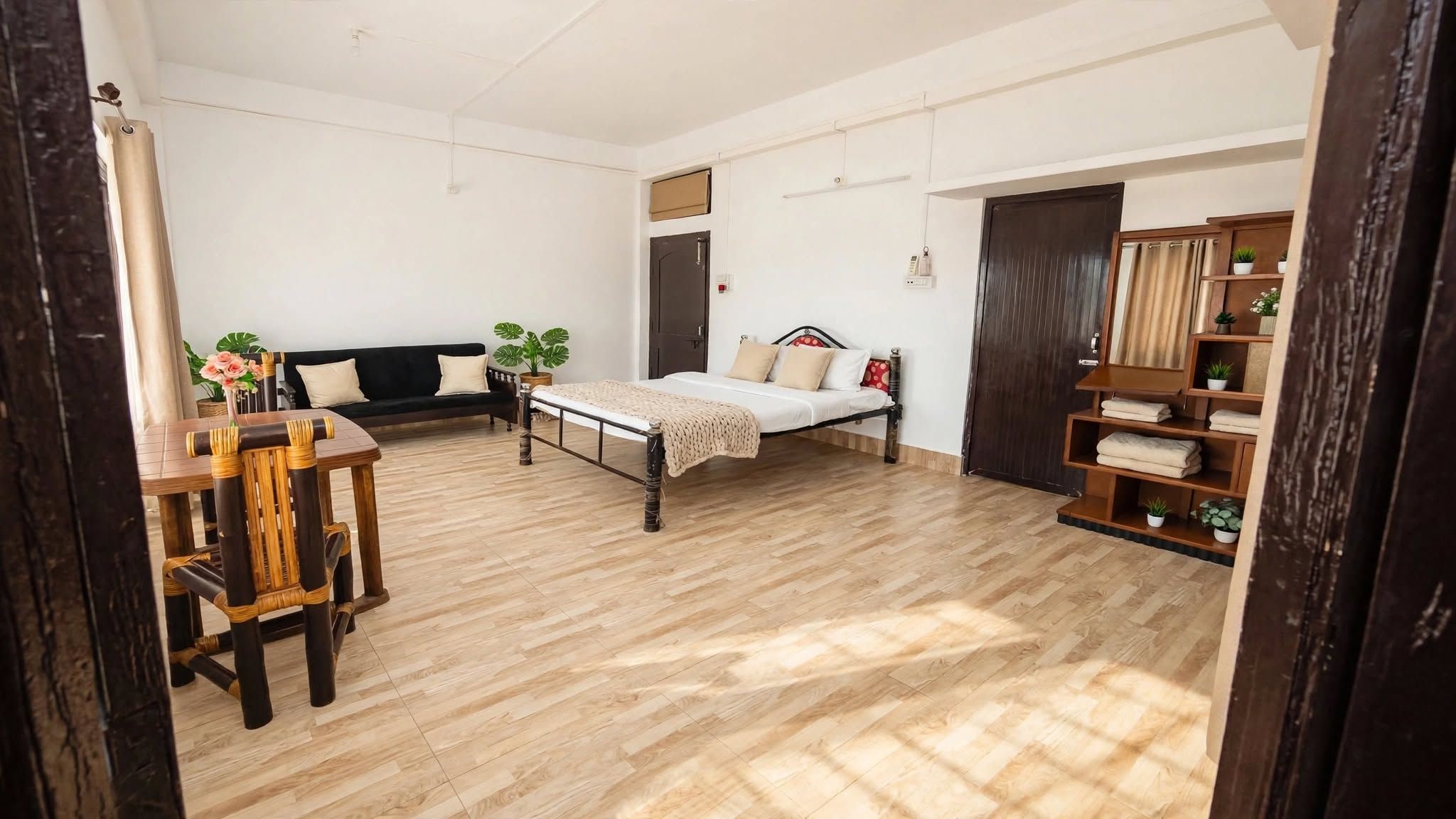 A room with a bed, a sofa, a dining table, and a bookshelf.