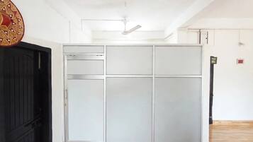 Una habitación con puerta corredera, ventilador de techo y suelo de madera.