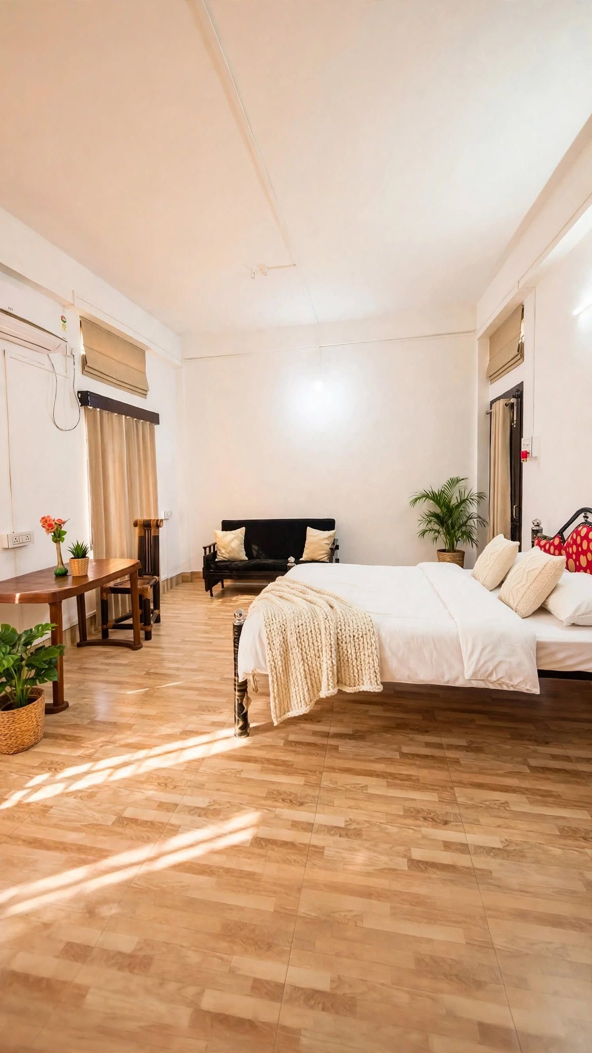 Un dormitorio con una cama, una mesita de noche, una silla, un ventanal con cortinas y una planta en maceta.