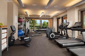 A gym with treadmills, elliptical machines, and free weights.