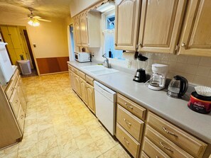 A kitchen with wooden cabinets, a sink, a microwave, a coffee maker, and a blender. - Vintage East Dallas 3 King Bed Retreat • Fire Pit • Grill Near White Rock Lake (Dallas)