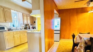 Una cocina amplia con armarios de madera, una isla central y un comedor con mesa y sillas.