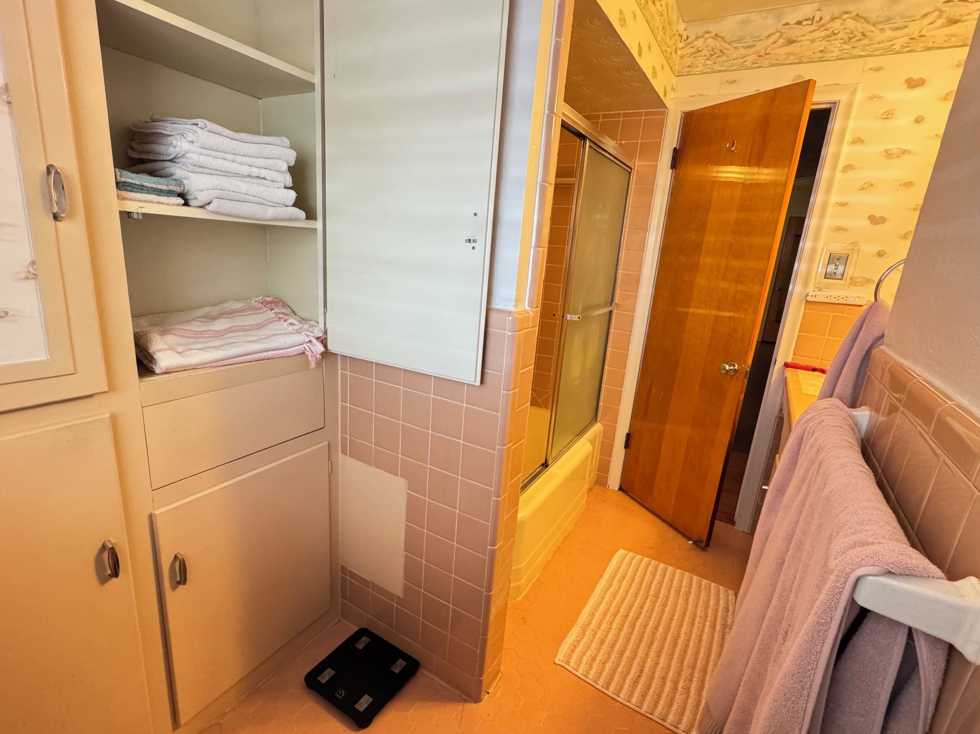 A bathroom with a shower, a towel rack, and a toilet.