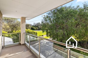 A balcony with a glass railing overlooking a green landscape and a road. - The Sorrento Sojourn *1 NIGHT FREE* Luxury Spa Retreat (Sorrento)