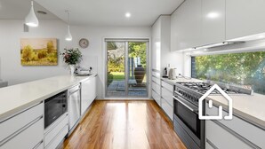 Una cocina moderna con una isla central, estufa y un amplio ventanal.