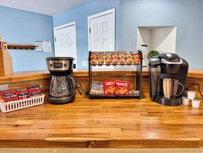 A coffee station with a Keurig coffee maker, a coffee pot, and a display of coffee pods and snacks. - No Stairs, Lakeside, beautiful patio and yard (Branson)
