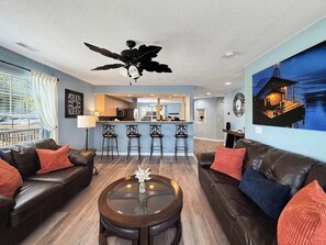 A modern living room with leather sofas, a glass coffee table, and a ceiling fan. - No Stairs, Lakeside, beautiful patio and yard (Branson)