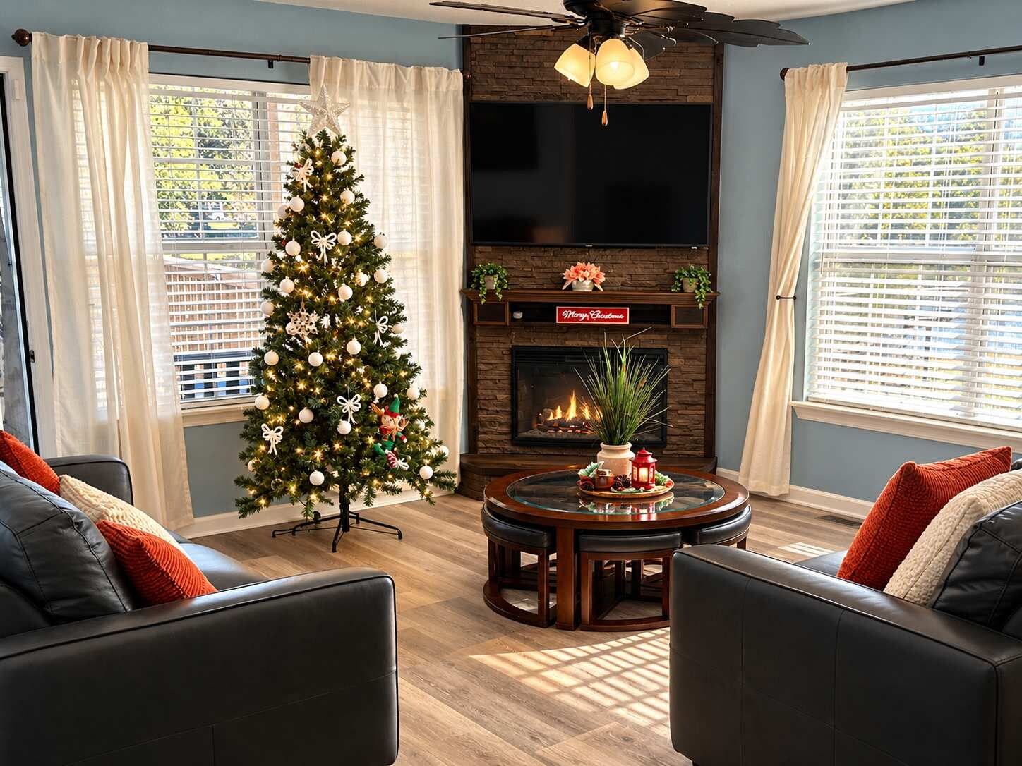Ein Wohnzimmer mit Weihnachtsbaum, Kamin und Deckenventilator.