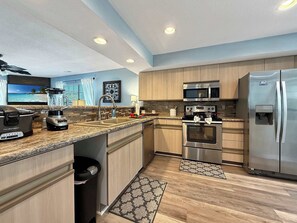A modern kitchen with granite countertops, stainless steel appliances, and a large island. - No Stairs, Lakeside, beautiful patio and yard (Branson)