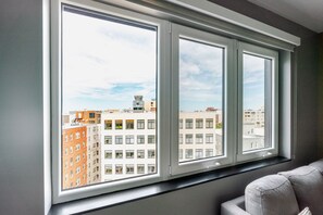 A room with a large window overlooking a cityscape. - Blueground | Downtown, gym, nr National Mall (Washington, D.C.)