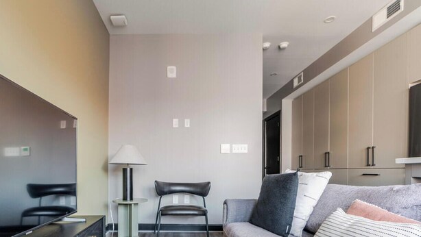 A modern living room with a flat-screen TV, a sofa, a coffee table, and a lamp. - Blueground | Downtown, gym, nr National Mall (Washington, D.C.)