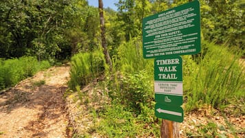 Un panneau indiquant le début du sentier de randonnée de Timber Walk, précisant qu’il s’agit d’un sentier de 7 600 pieds de long et de difficulté facile.