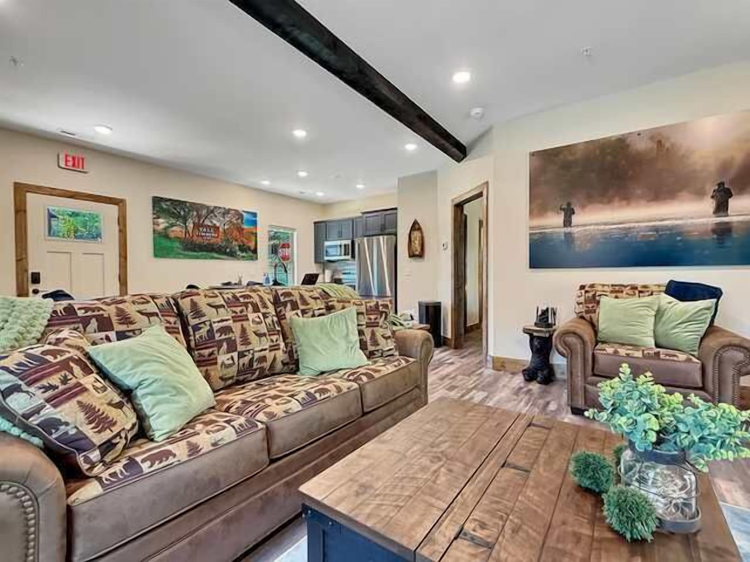 A furnished living room with a sofa set, a coffee table, and a painting on the wall.