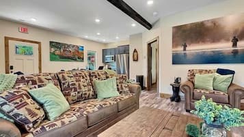 A furnished living room with a sofa set, a coffee table, and a painting on the wall.