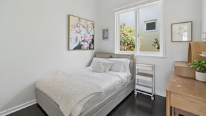 Una camera da letto con un letto, una finestra e opere d'arte alle pareti.