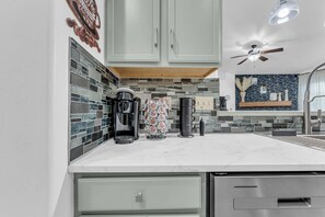 A modern kitchen with a coffee station, a microwave, and a coffee maker.