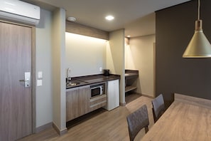A modern kitchen with a built-in microwave, a sink, and a coffee maker.