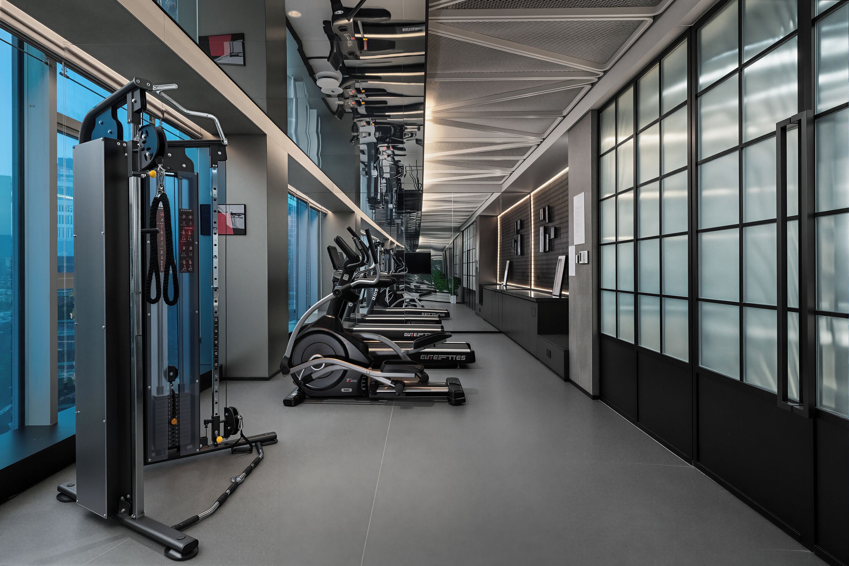 A gym with cardio machines, weightlifting equipment, and a mirrored wall.