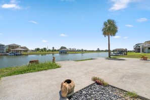 A waterfront property with a clear view of the water, a palm tree, and a gazebo.