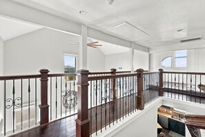 A spacious interior with a wooden staircase, a view of the outdoors, and a kitchen area.