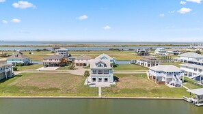 A coastal residential area with houses, a marina, and a view of the ocean.