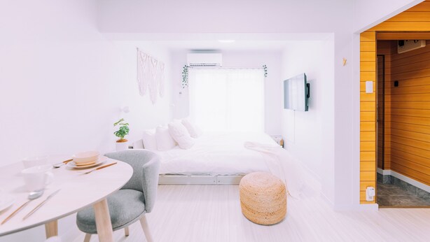 A modern, minimalist bedroom with a bed, bedside table, and a view of the outside. - Maison de Tenjin Higashi 506 (Fukuoka)
