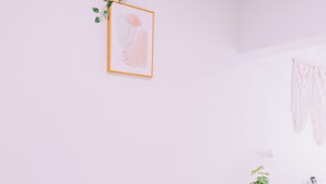 A minimalist dining area with a round table, two chairs, and a framed artwork on the wall. - Maison de Tenjin Higashi 506 (Fukuoka)