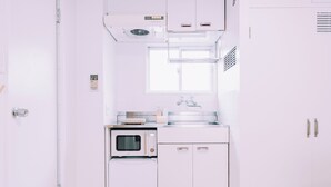 A compact kitchen with a built-in oven, a microwave, and a sink. - Maison de Tenjin Higashi 506 (Fukuoka)