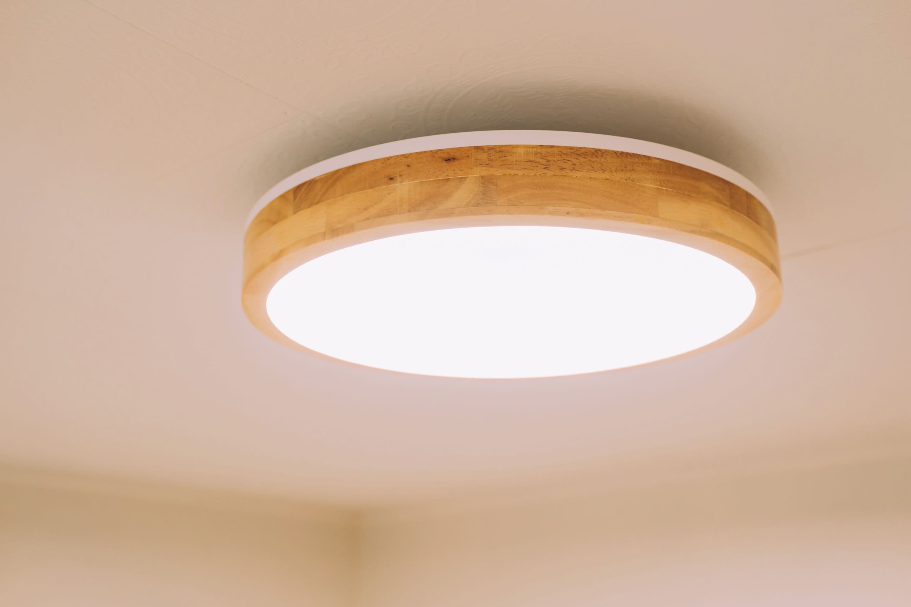 A circular wooden ceiling fixture with a white light source.