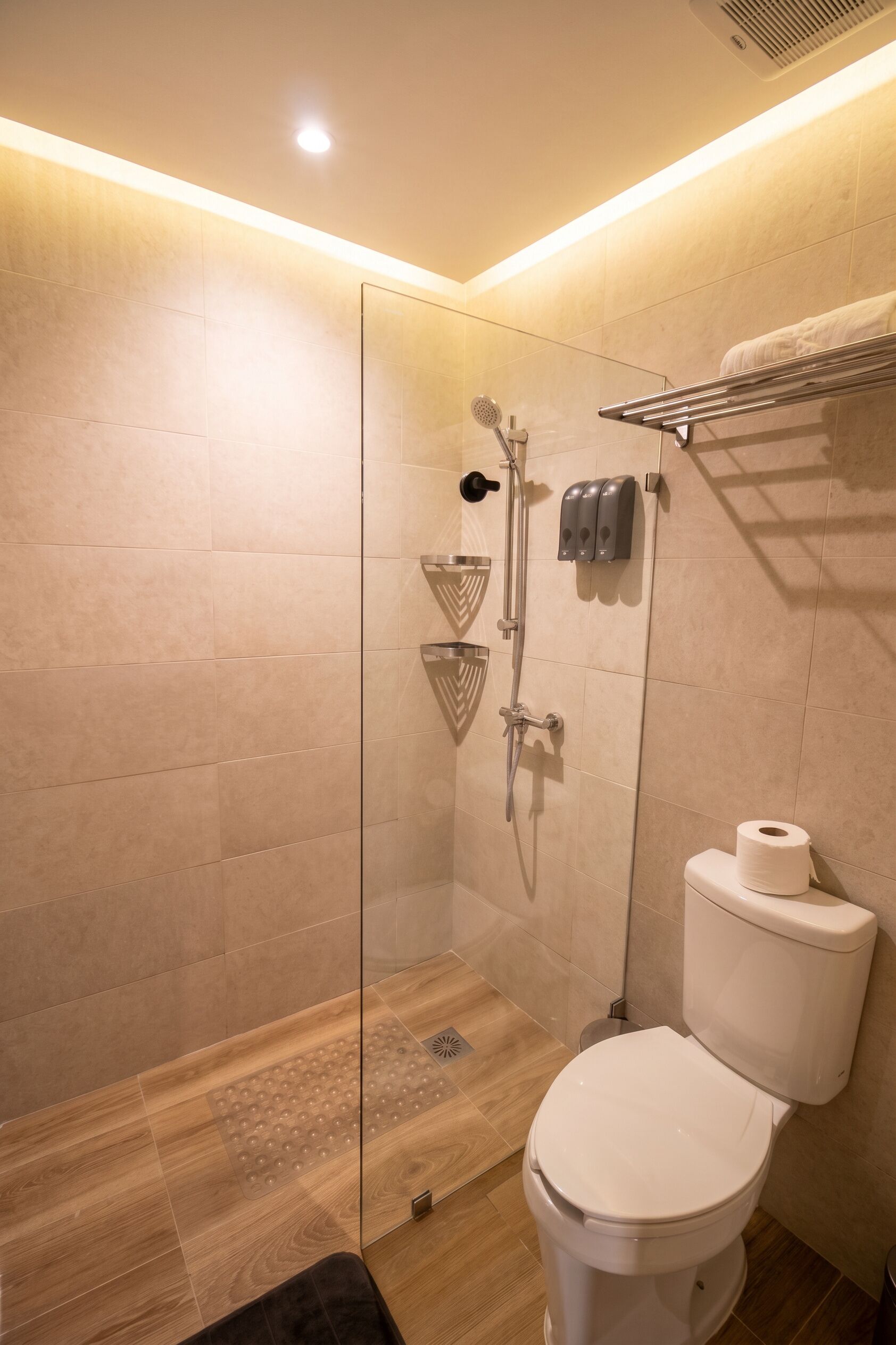 Ein modernes Badezimmer mit Duschkabine aus Glas, Toilette und Handtuchhalter.
