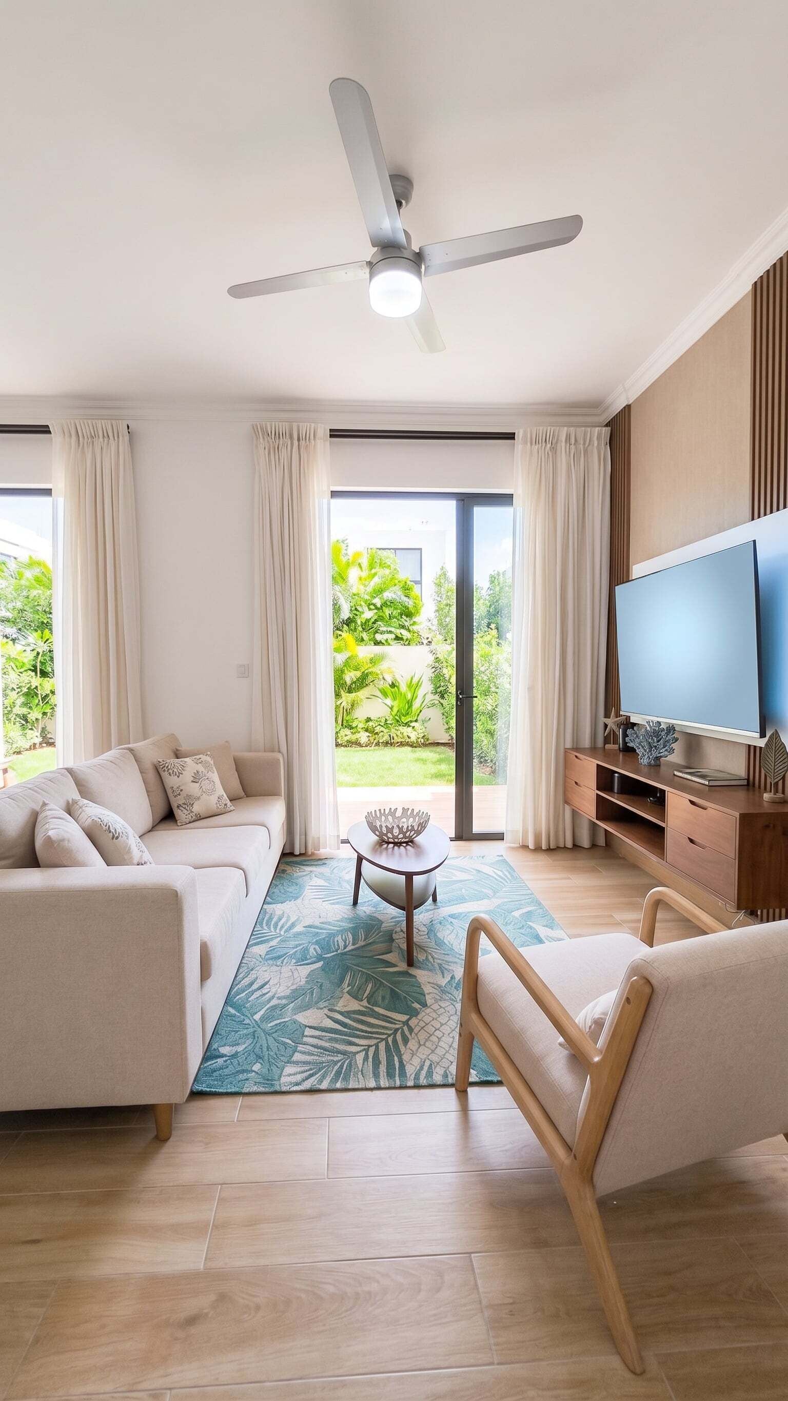 A modern living room with a sofa, armchair, coffee table, and a flat-screen TV.