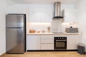 A modern kitchen with a stainless steel refrigerator, a built-in oven, and a microwave. - 2-bedroom apartment in lovely Punta Cana with AC and gym access (Punta Cana)