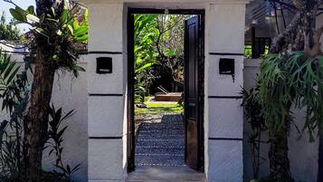 A traditional gate with a tiled roof, leading to a pathway.