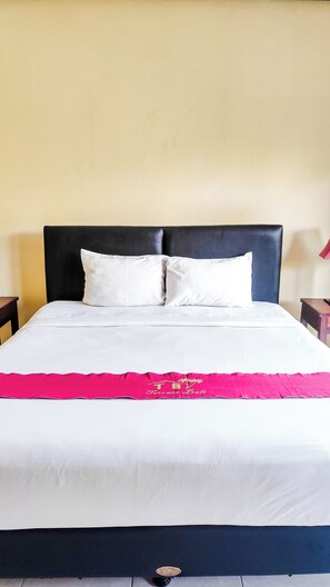 A bed with a black headboard, white bedding, and a pink decorative item. - Oemah Bali Nusa Dua (Nusa Dua)