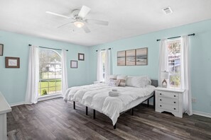 A bedroom with a bed, a nightstand, a ceiling fan, and a window with curtains. - Tee & Sea | Pool, Golf & 8 Mi to Navarre Beach (Navarre)