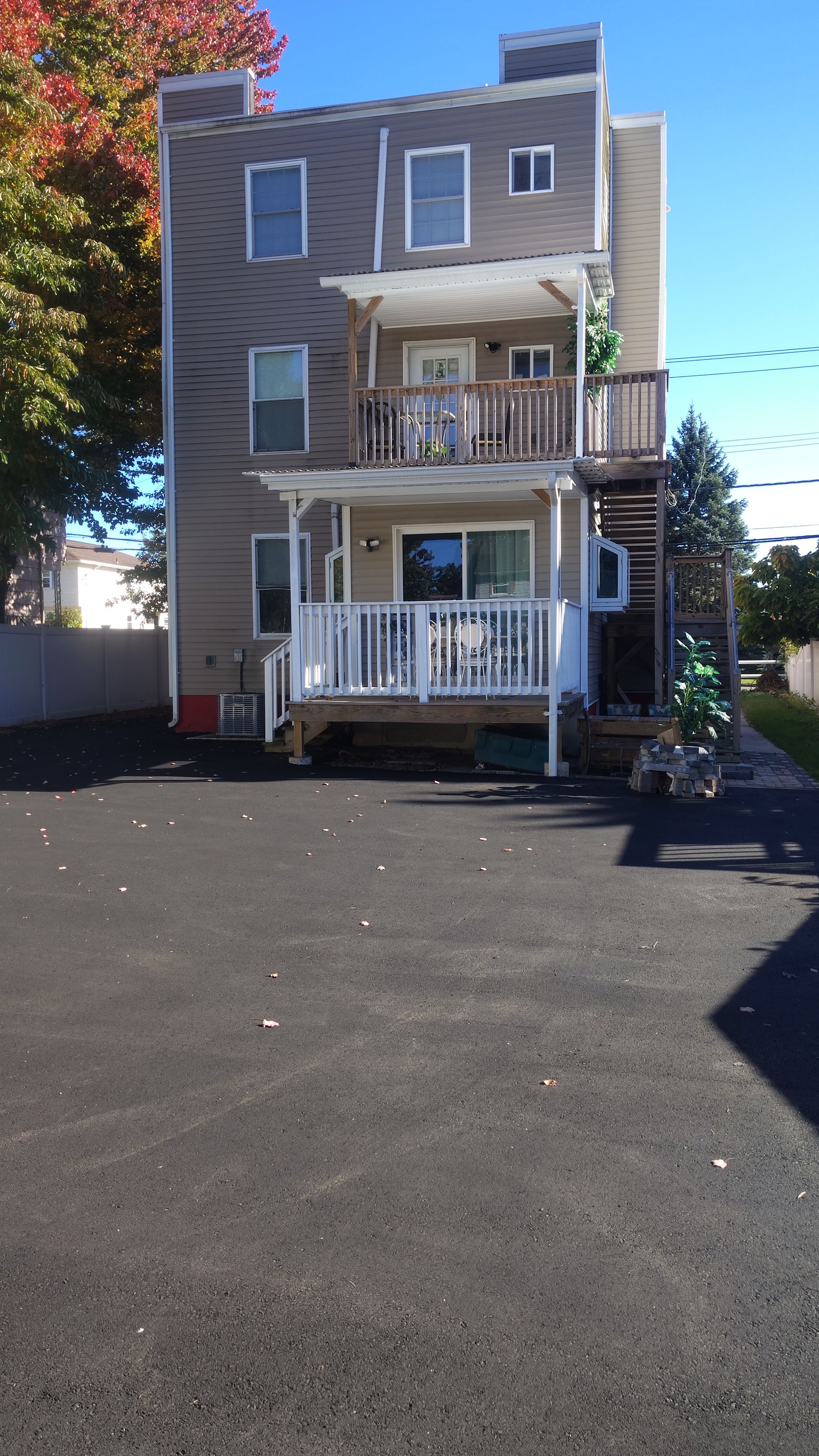 A two-story building with a front porch, a covered entryway, and a small front yard.