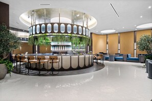 A modern bar area with a circular design, seating arrangements, and greenery. - 38th Floor E11EVEN Retreat w/ Skyline Views (Miami)