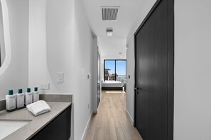 A modern hotel room with a bathroom, a bed, and a view of the cityscape. - 36th Floor E11EVEN Escape w/ Bay & City Views (Miami)