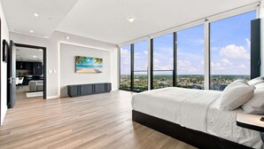 A modern bedroom with a large bed, a city view, and a painting on the wall. - 44th Floor at E11EVEN with Panoramic City Views (Miami)