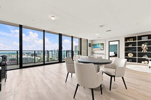 Ein geräumiges Zimmer mit großem Fenster, einem runden Tisch und modernen Möbeln.