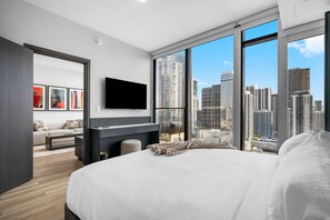 A modern hotel room with a large bed, a flat-screen TV, a sofa, and a city view. - 32nd Floor E11EVEN w/ Rooftop Pool & Skyline Views (Miami)