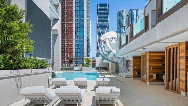 A rooftop pool area with lounge chairs, a swimming pool, and modern buildings in the background. - 32nd Floor E11EVEN w/ Rooftop Pool & Skyline Views (Miami)