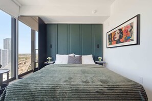 A modern bedroom with a large bed, a city view, and a framed artwork on the wall. - 15th Floor E11EVEN Retreat Near Miami Worldcenter (Miami)