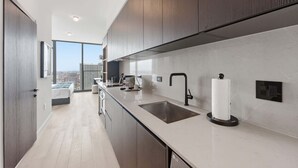 A modern kitchen with a large window, a sink, and a toilet paper holder. - E11EVEN Studio Suite w/ Rooftop Pool & City Views (Miami)